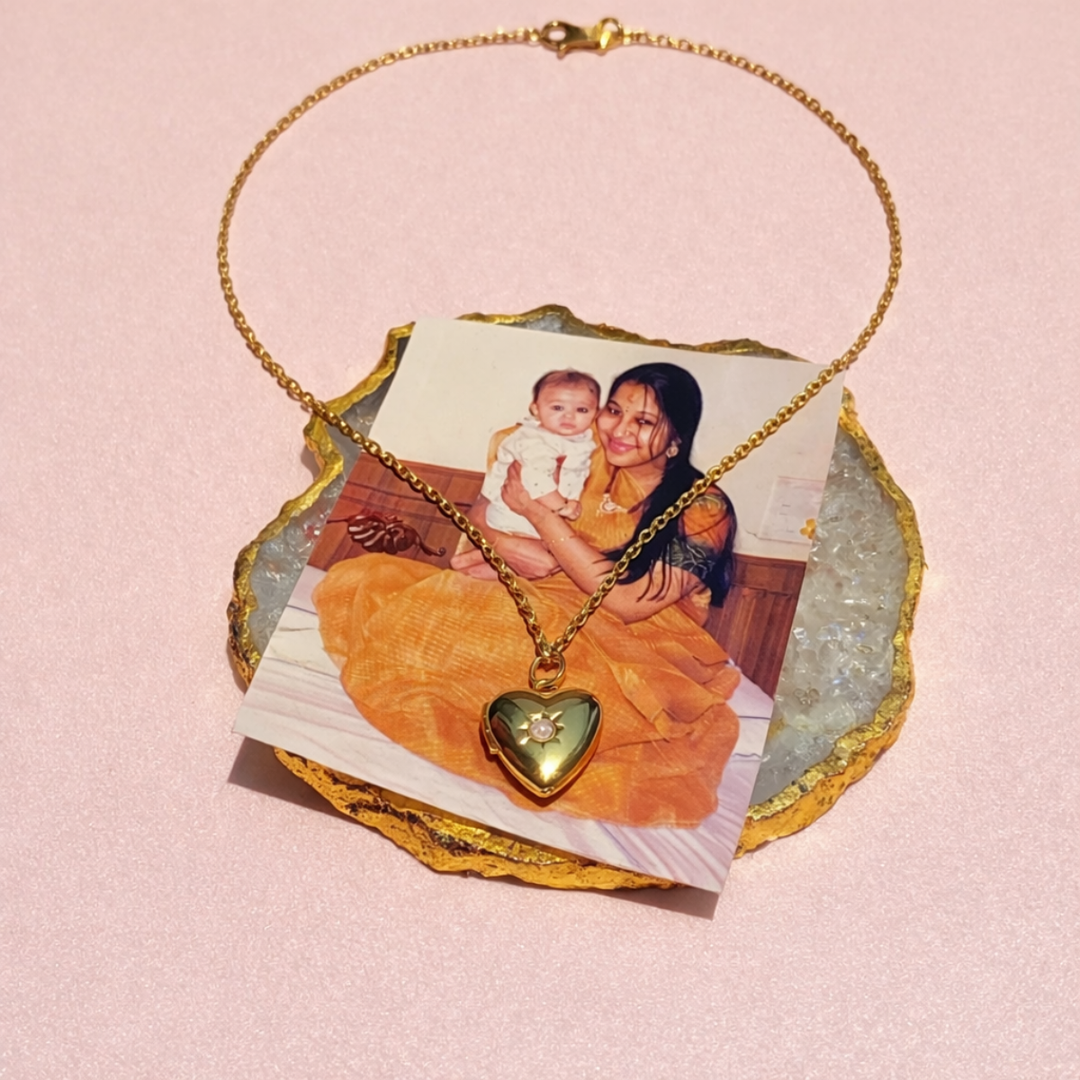 Necklace with a heart-shaped locket on a stone plaque featuring a photo of a woman holding a baby.