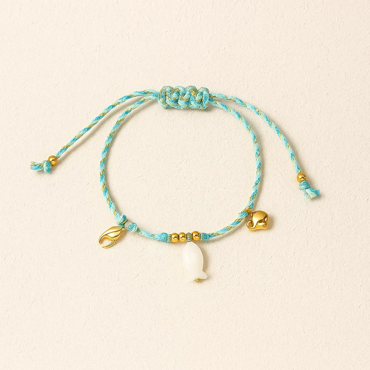 Knotty bracelet, 18kt gold plated stainless steel beach & fish charm threaded bracelet
