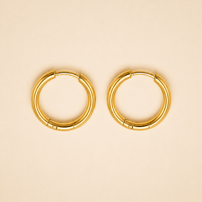 A pair of gold-plated circular hoop earrings with a segmented, tubular design, displayed on a solid light beige background.